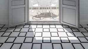 A room with a balcony, white tiled floor, and a view of the sea.