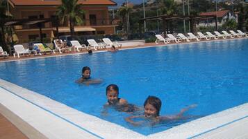 Piscine extérieure, parasols de plage, chaises longues