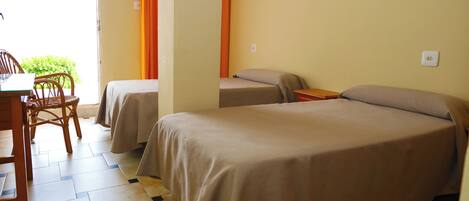 Une chambre avec deux lits, une table et des chaises.
