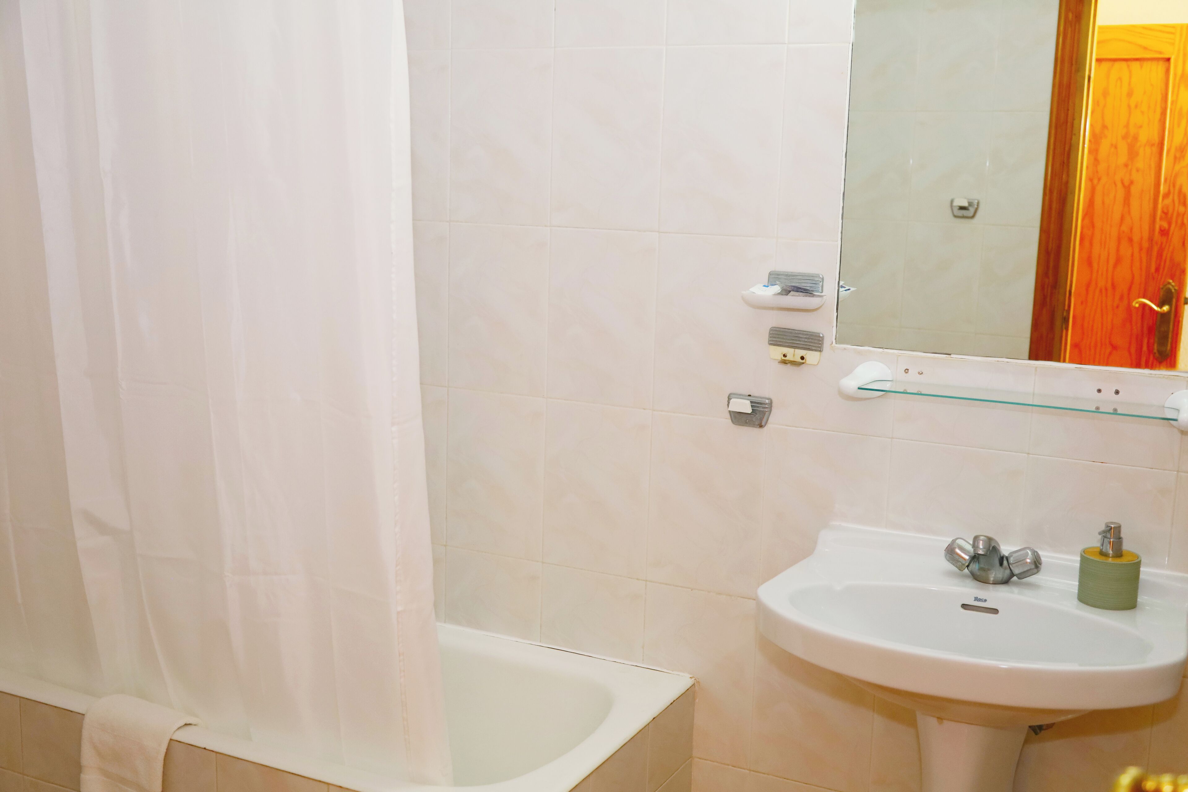 Ein Badezimmer mit Badewanne, Waschbecken und Spiegel.