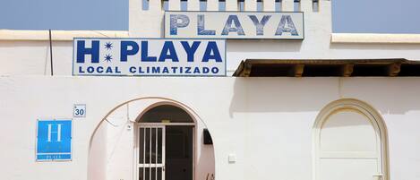 Un letrero de hotel con la leyenda 'HOTEL PLAYA' y 'H PLAYA LOCAL CLIMATIZADO'.