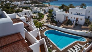 A resort with a swimming pool, white buildings, and a view of the sea. - Boutique Hotel El Tio Kiko (Nijar)