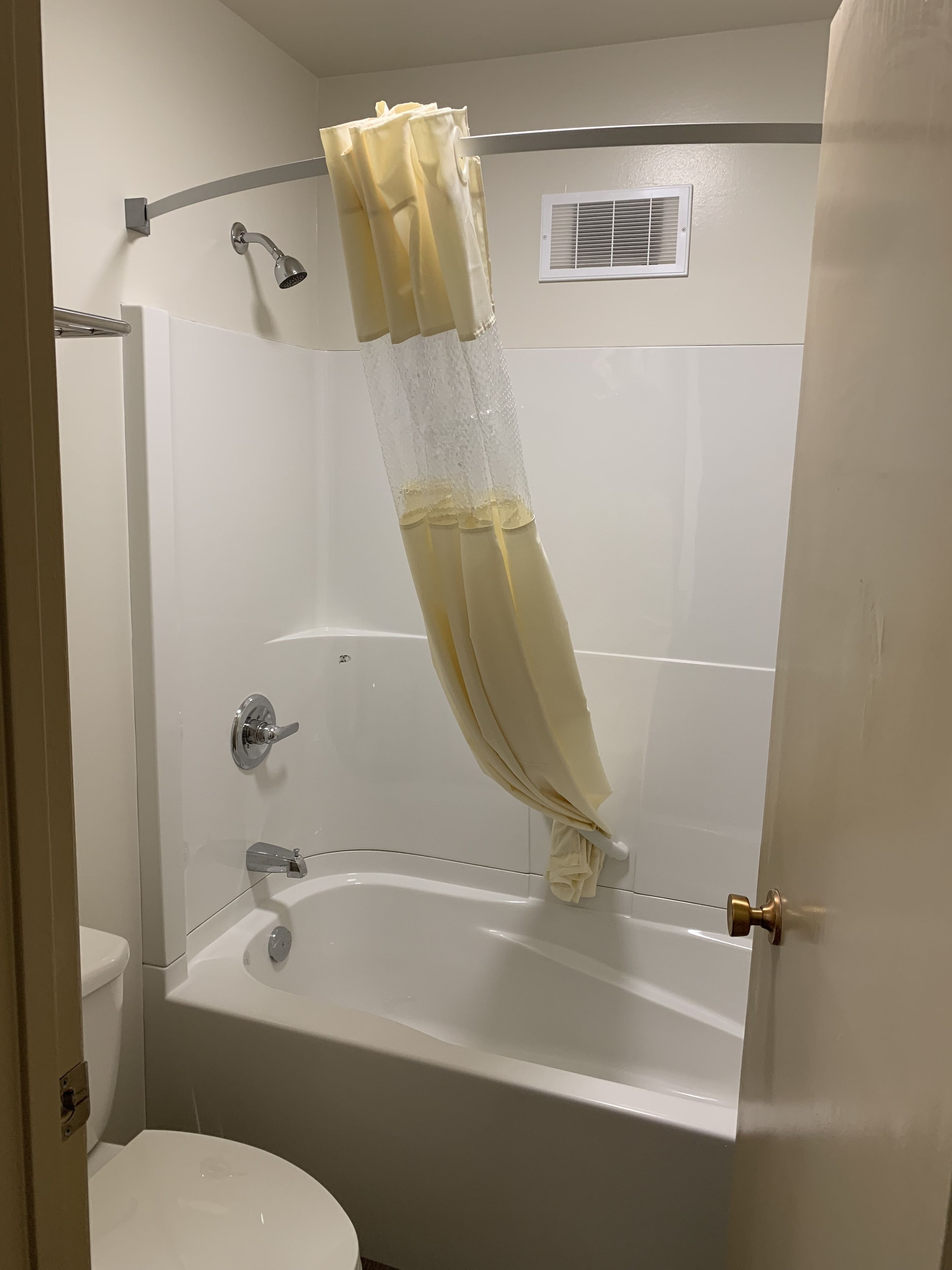 Une salle de bain avec une baignoire, des toilettes et un rideau de douche.
