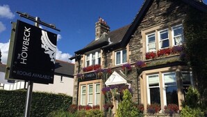 A traditional stone building with a sign for "The Howbeck" indicating rooms are available. - Howbeck Guest House (Windermere)