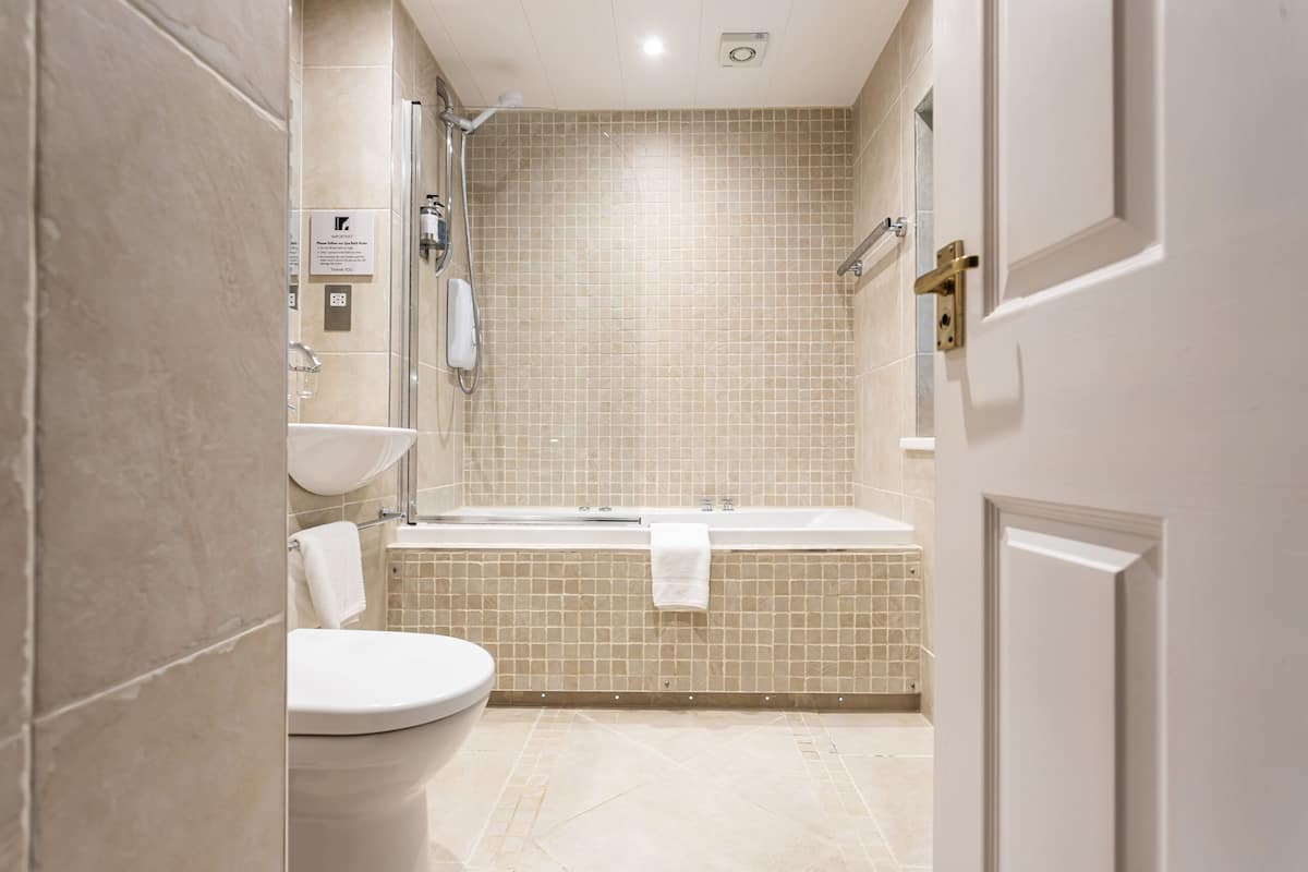 A bathroom with a toilet, sink, and bathtub.