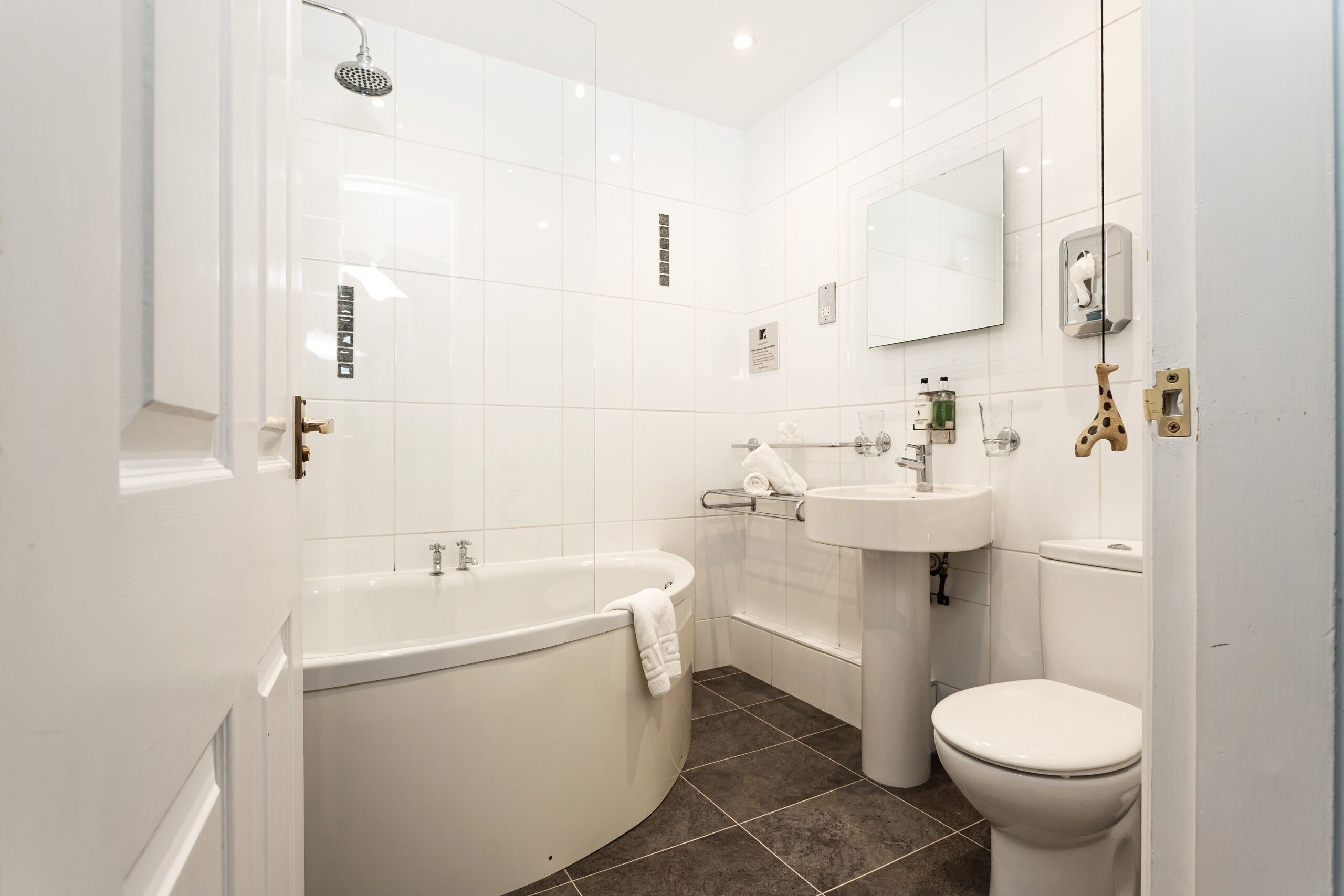 A modern bathroom with a bathtub, toilet, and sink.
