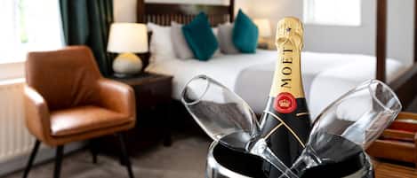 A minibar with a bottle of Moët champagne, a glass, and a wine glass.