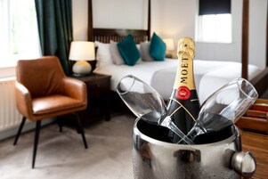 A minibar with a bottle of Moët champagne, a glass, and a wine glass.