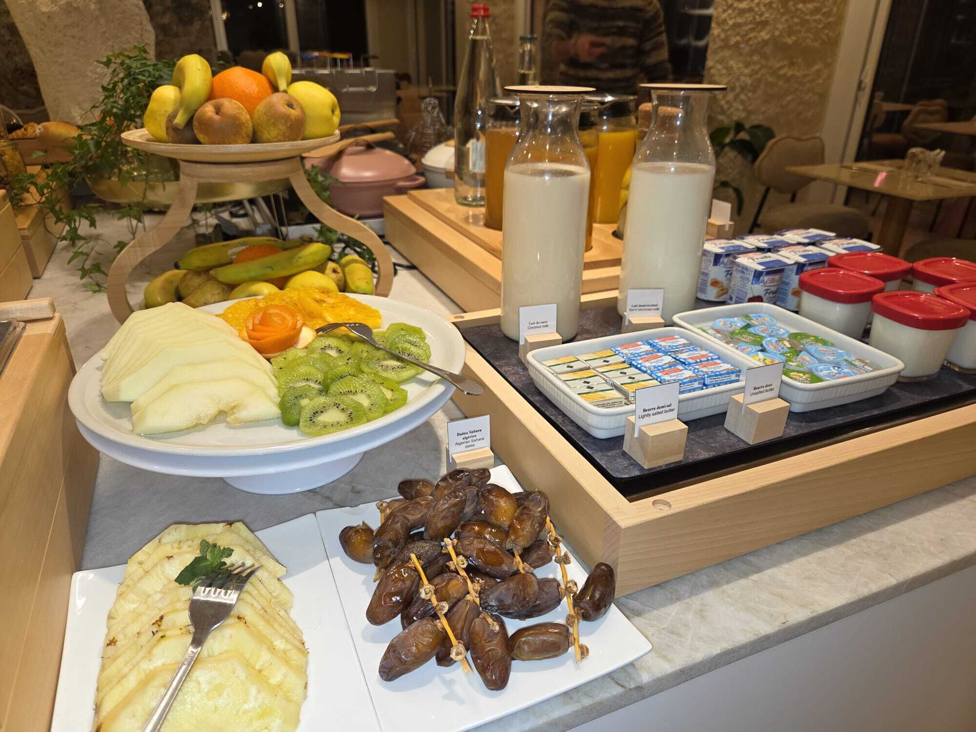 Un buffet de petit-déjeuner proposant une variété de fruits, de produits laitiers et un assortiment de fromages.