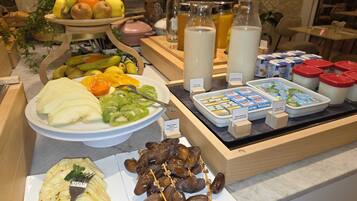 Un buffet de petit-déjeuner proposant une variété de fruits, de produits laitiers et un assortiment de fromages.