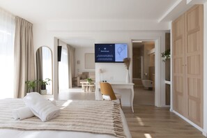 A modern hotel room with a bed, a desk, and a TV displaying a welcome message. - Hotel Astoria (Saint-Etienne)