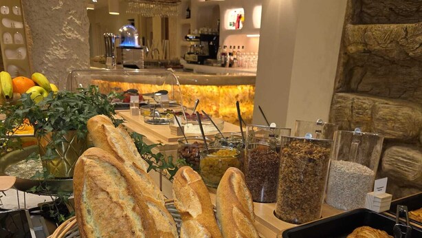 A bakery display with various types of bread, including baguettes and croissants, and a selection of fruits and vegetables. - Hotel Astoria (Saint-Etienne)