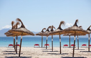 Una playa cerca, arena blanca, sillas reclinables de playa, sombrillas