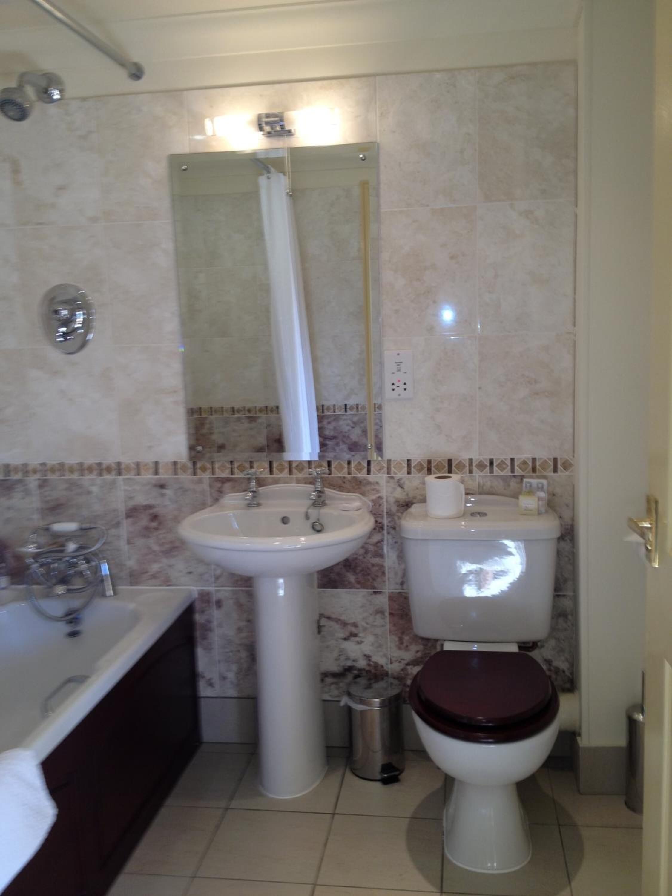 Un baño con lavamanos, inodoro y ducha.