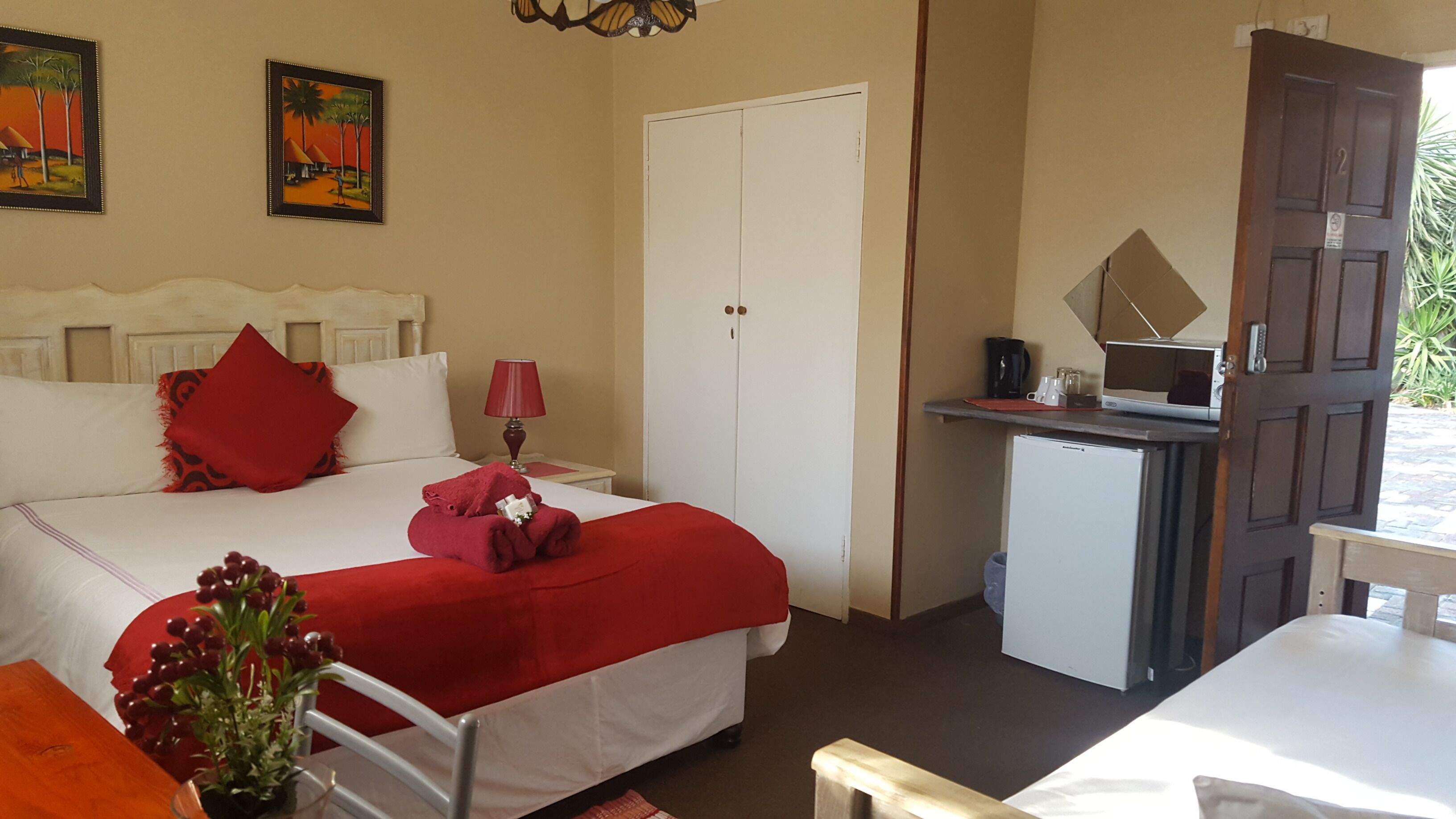 Une chambre d’hôtel avec un lit, un bureau, une télévision et une porte.