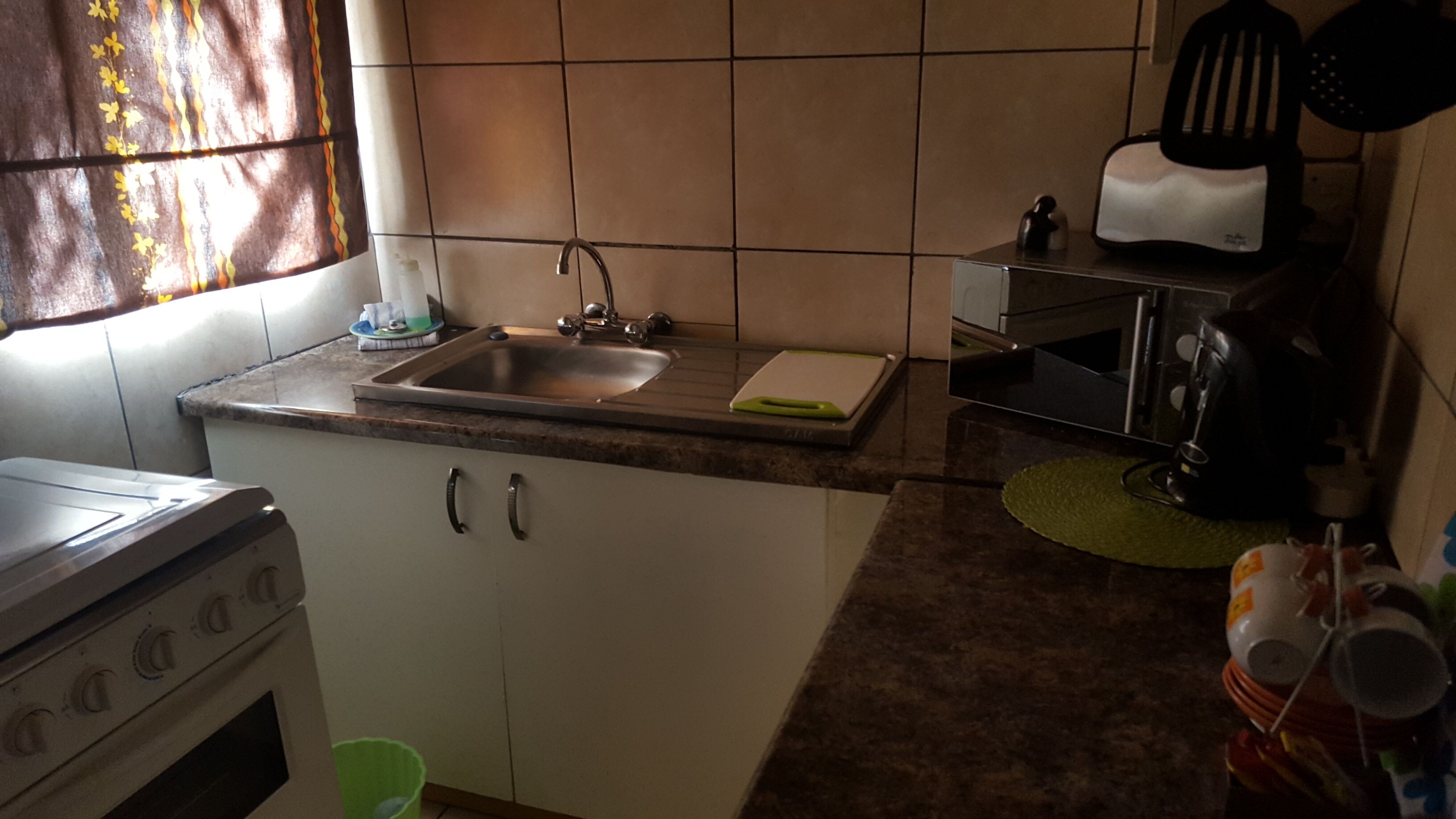 Una cocina con pileta, estufa y alacenas.
