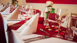 A table set for dining with red tablecloths, white napkins, and clear glassware. - Savoy (Ceske Budejovice)