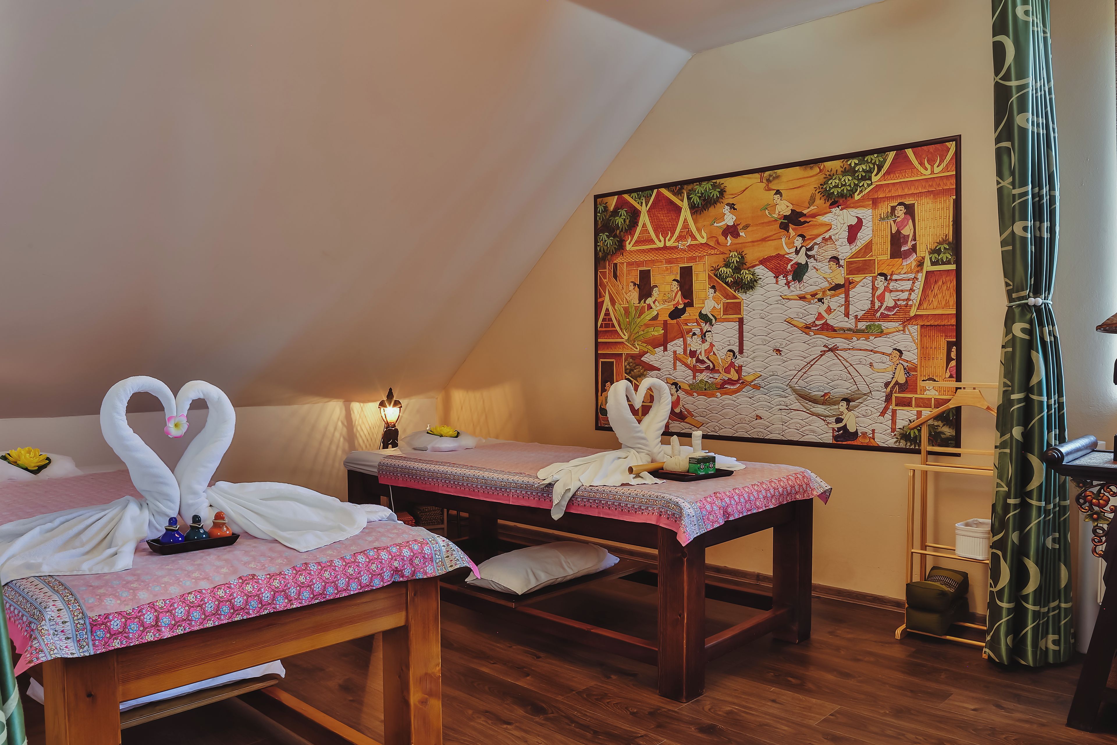 A room with two beds, a painting, and a curtain.