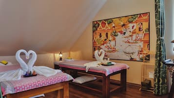 A room with two beds, a painting, and a curtain.