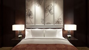 Una habitación de hotel con una cama grande, dos mesitas de noche con lámparas y un panel decorativo en la pared.