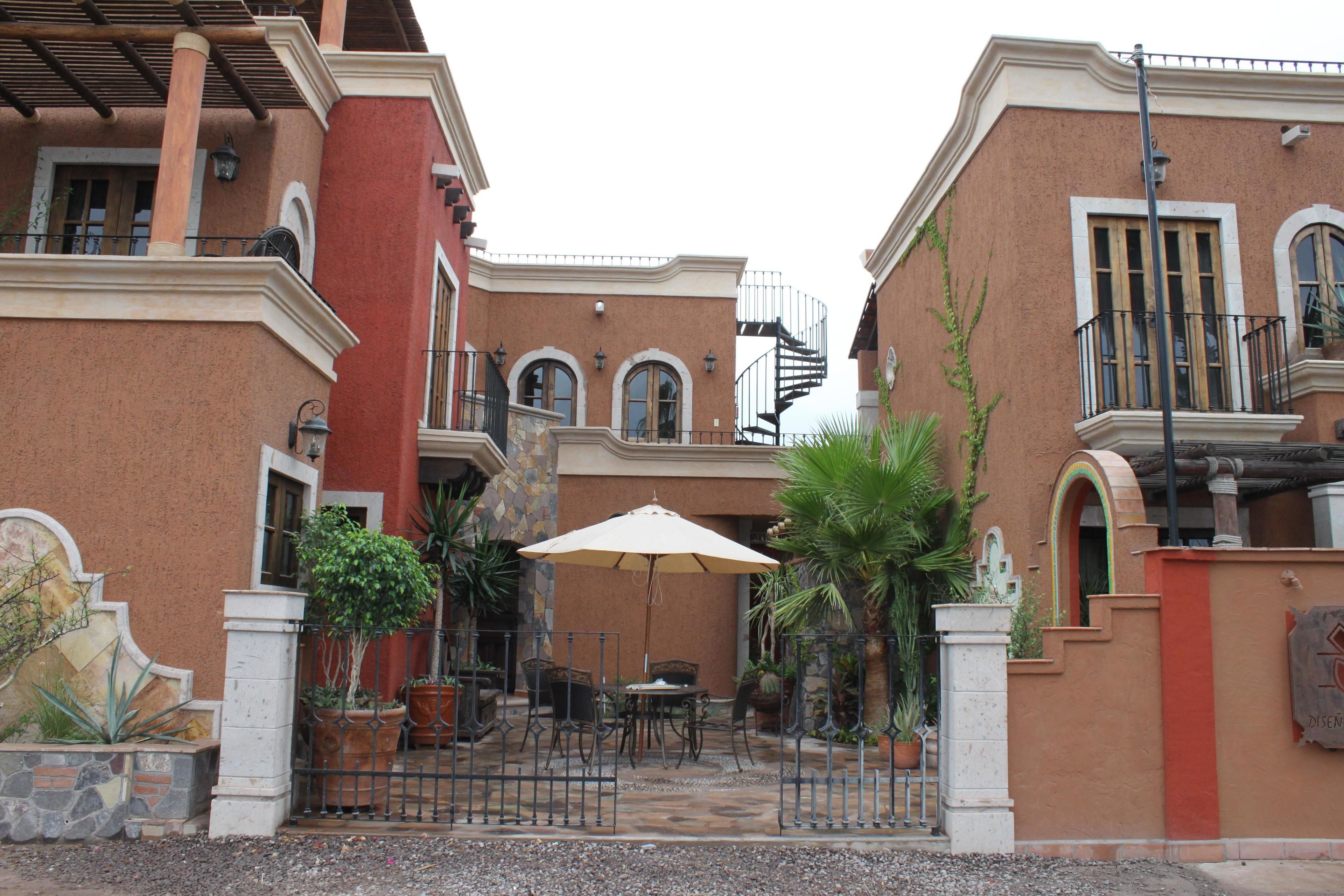 A courtyard with a patio, outdoor seating, and potted plants.
