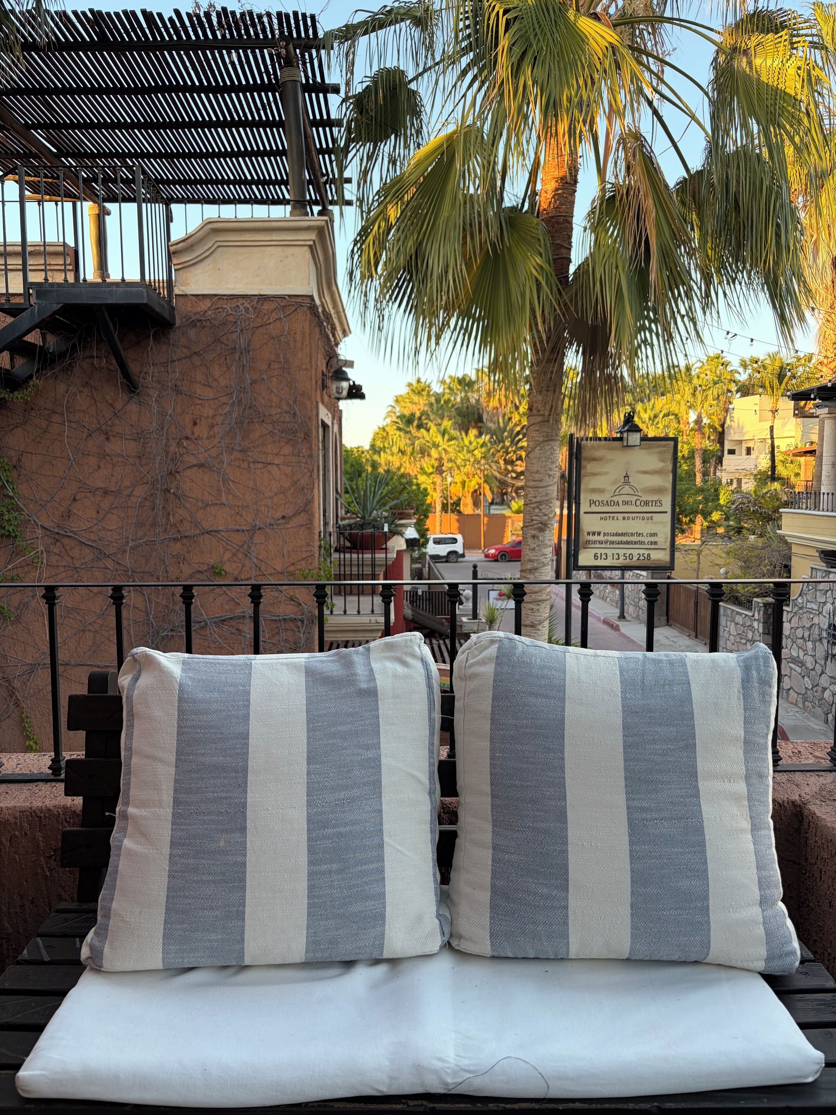A lounge area with striped cushions and a view of a hotel sign in the background.