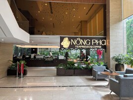 A modern indoor space with a coffee shop named 'NONG Phan' offering espresso and coffee.