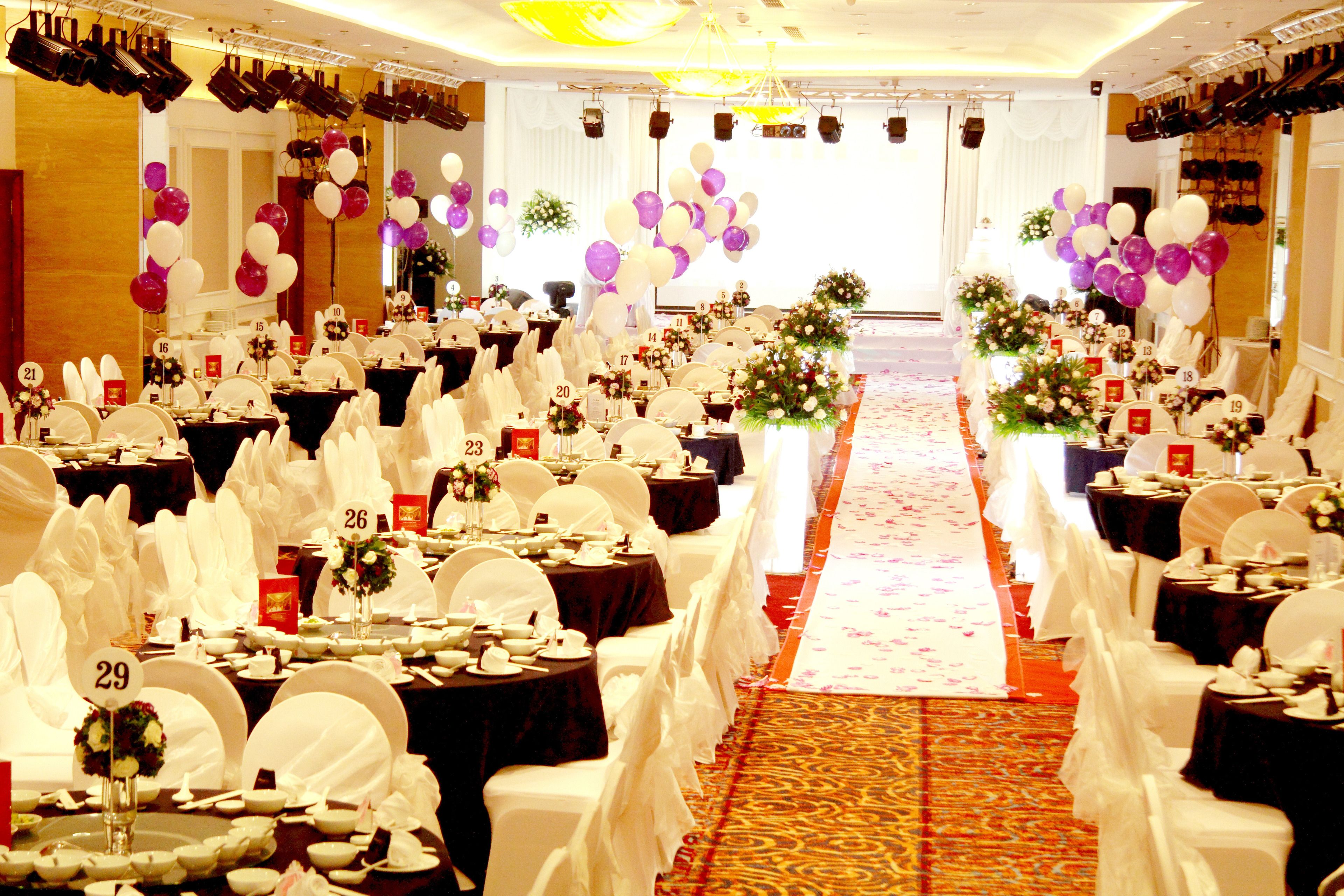 A banquet hall with rows of tables, numbered place cards, and white tablecloths.