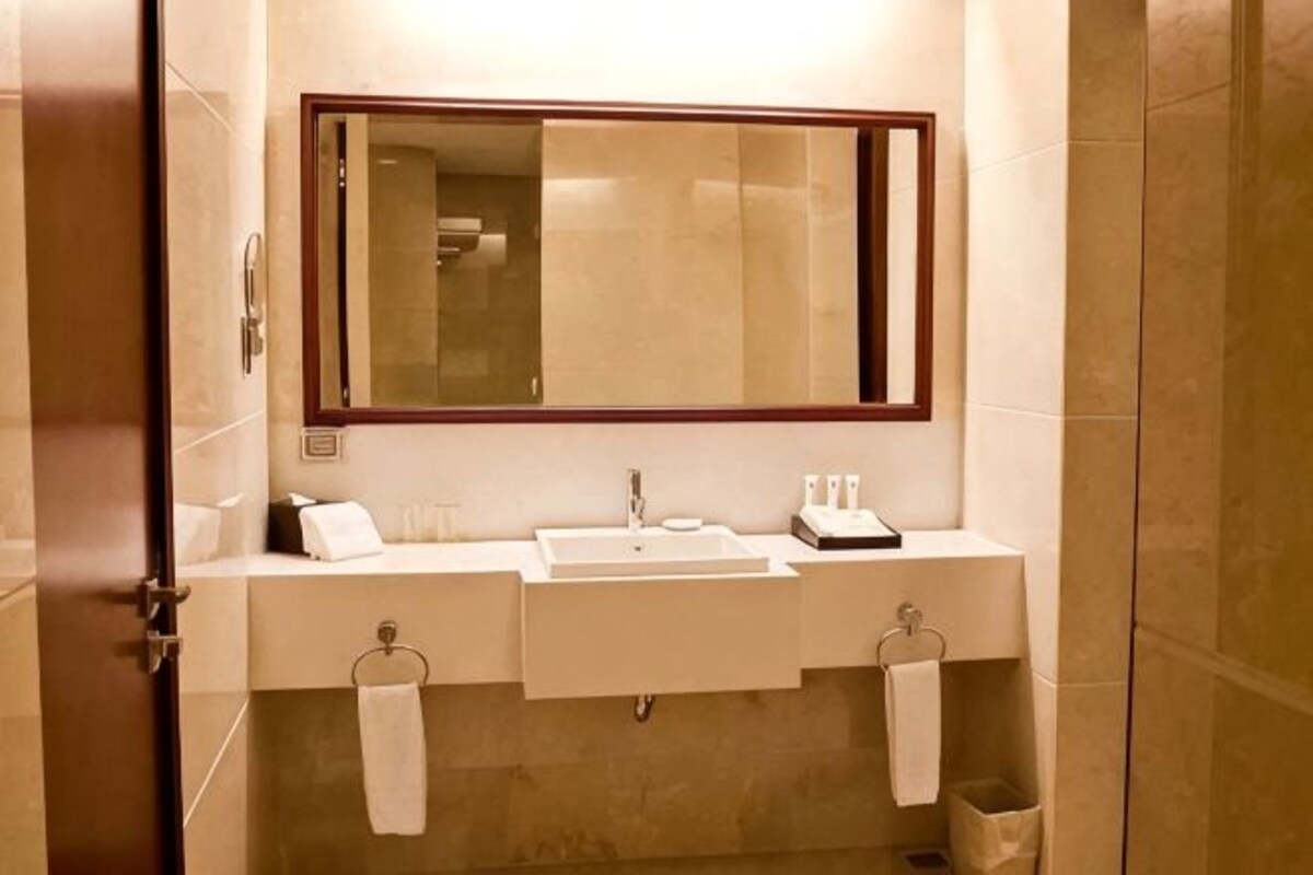 Baño con lavamanos doble, espejo y toallero.