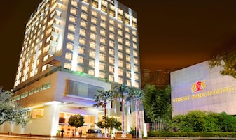A high-rise hotel with a modern facade, multiple balconies, and a prominent sign for Vissai Saigon Hotel.