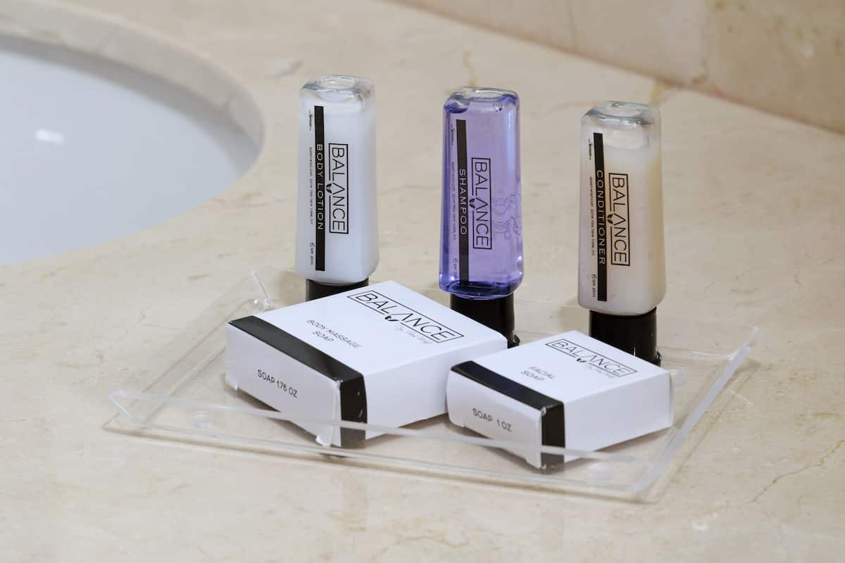 Three bottles of BALANCE body lotion and two boxes of BALANCE soap on a clear plastic stand.