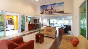 Eine Lobby mit Empfangsschalter, Sitzgelegenheiten und einer Glaswand.
