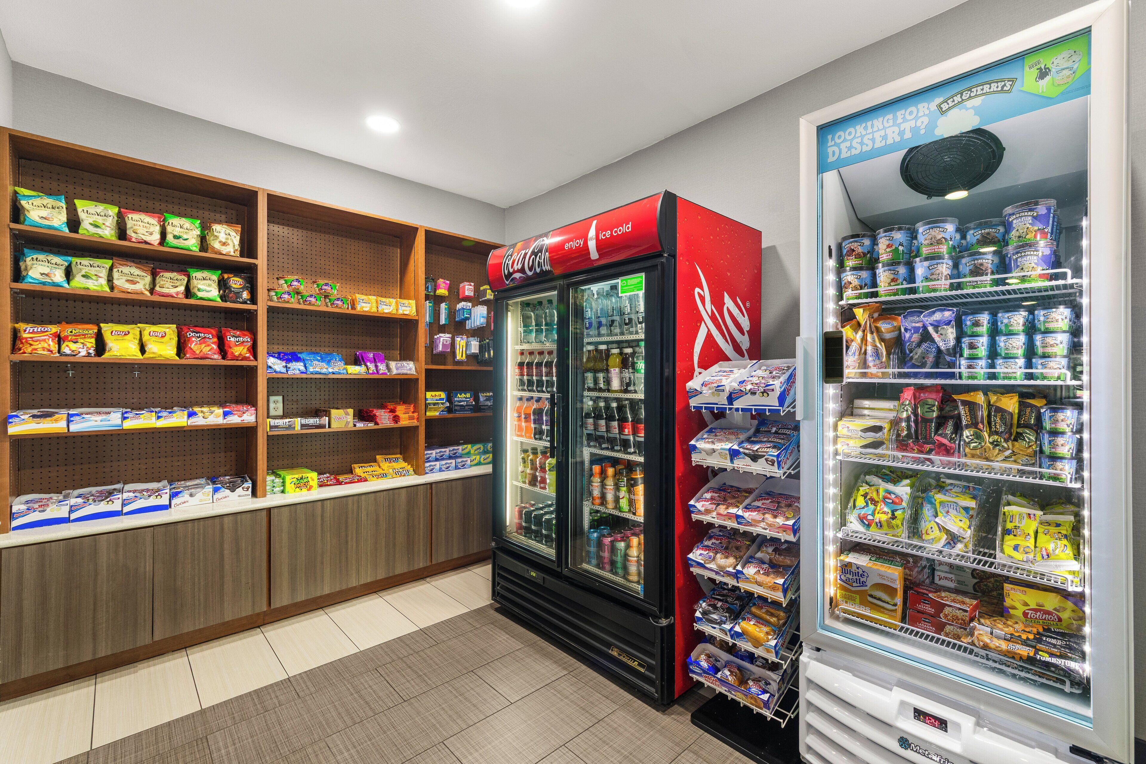 Een automaatgedeelte met snacks en drankjes, inclusief Coca-Cola en een automaat voor desserts.