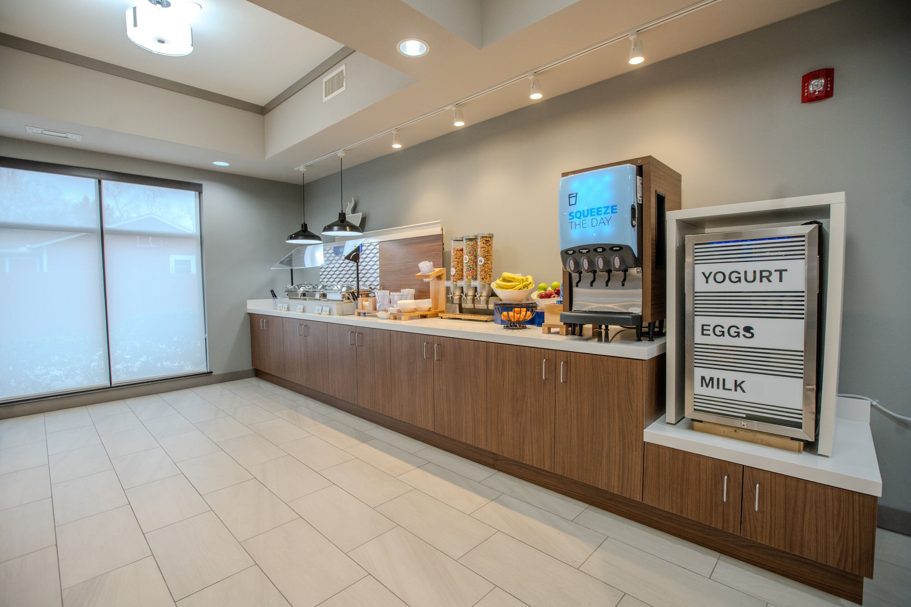 Una cucina moderna con un bancone per la colazione, un distributore di yogurt e una macchina per il caffè.