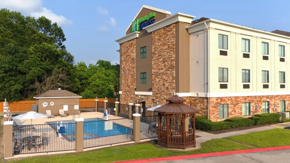 A Holiday Inn Express hotel with a pool area, outdoor seating, and a gazebo.