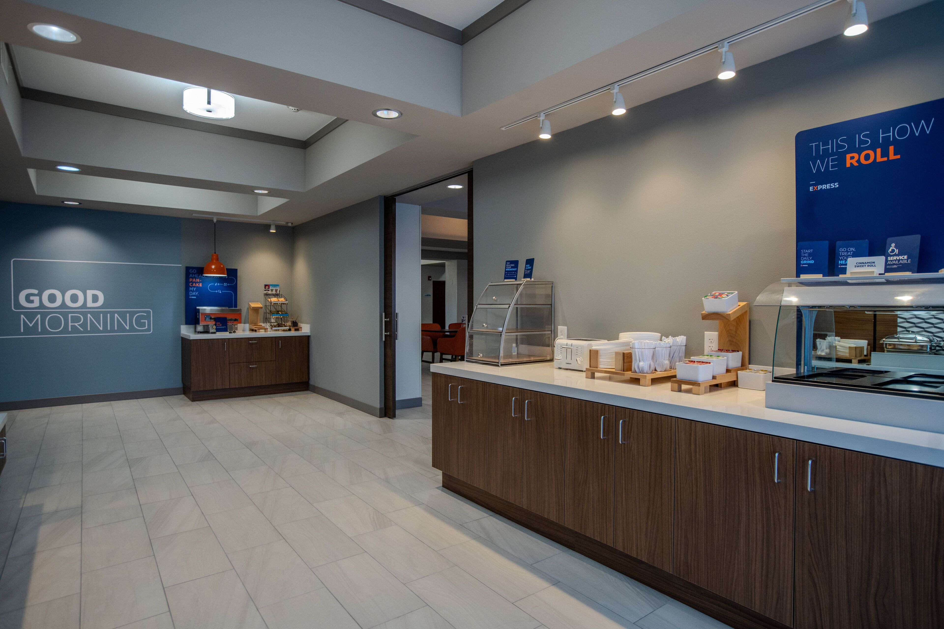 A modern kitchen area with a countertop, cabinets, and a sign that reads "GOOD MORNING".