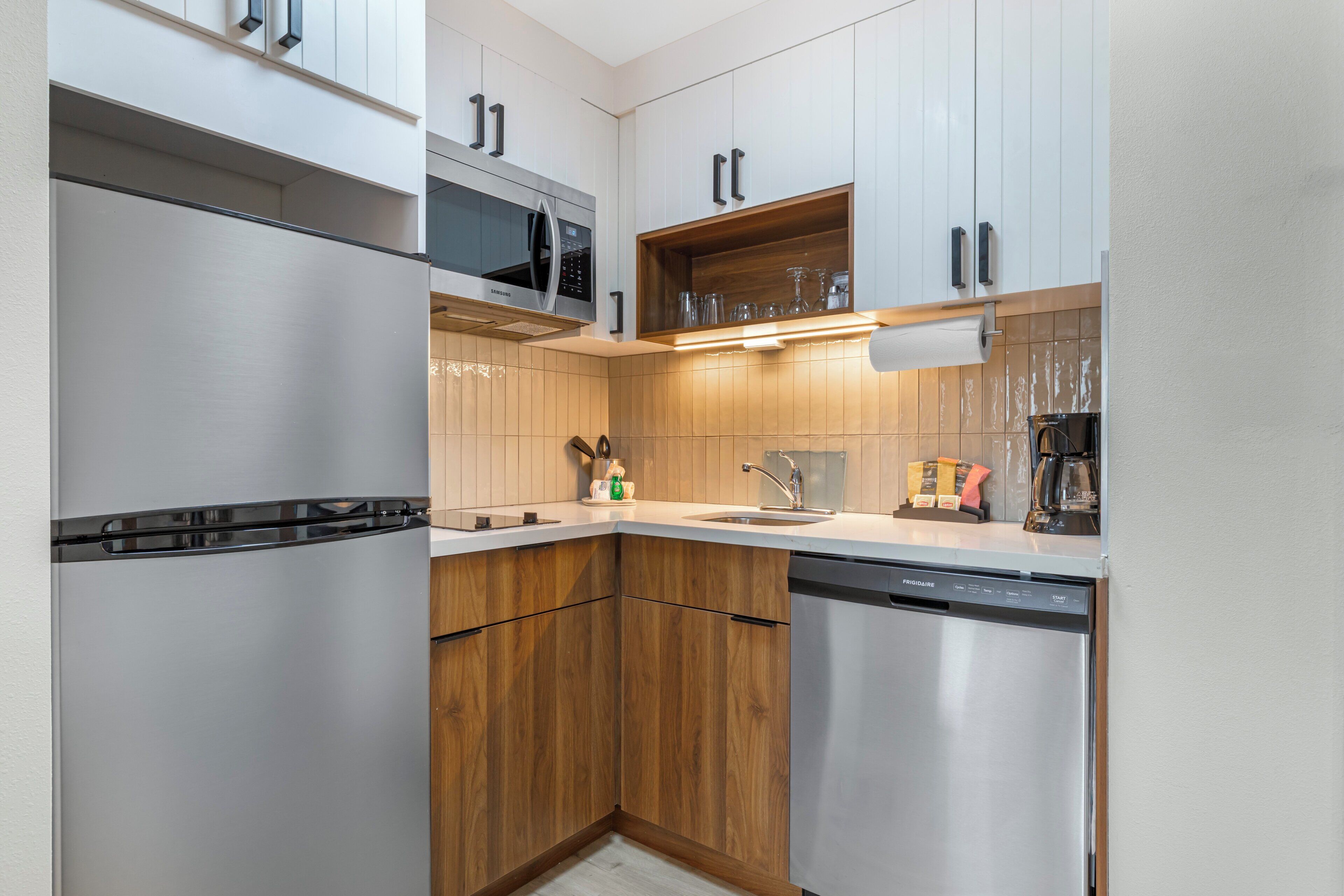 Una cocina moderna con electrodomésticos de acero inoxidable, armarios de madera y microondas integrado.