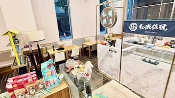 A modern cafe interior with seating, a counter, and a display of packaged goods.