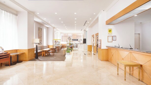 A hotel lobby with a reception desk, seating area, and a view of the dining area. - Hotel Sunroute Taipei (Taipei)