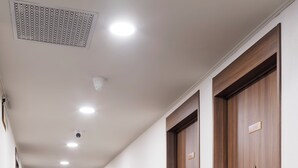 A hotel hallway with wooden doors, a patterned carpet, and recessed ceiling lights. - Hotel Sunroute Taipei (Taipei)