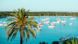 A marina with multiple boats docked, surrounded by greenery and a clear sky. - Hotel Honucai (Ses Salines)