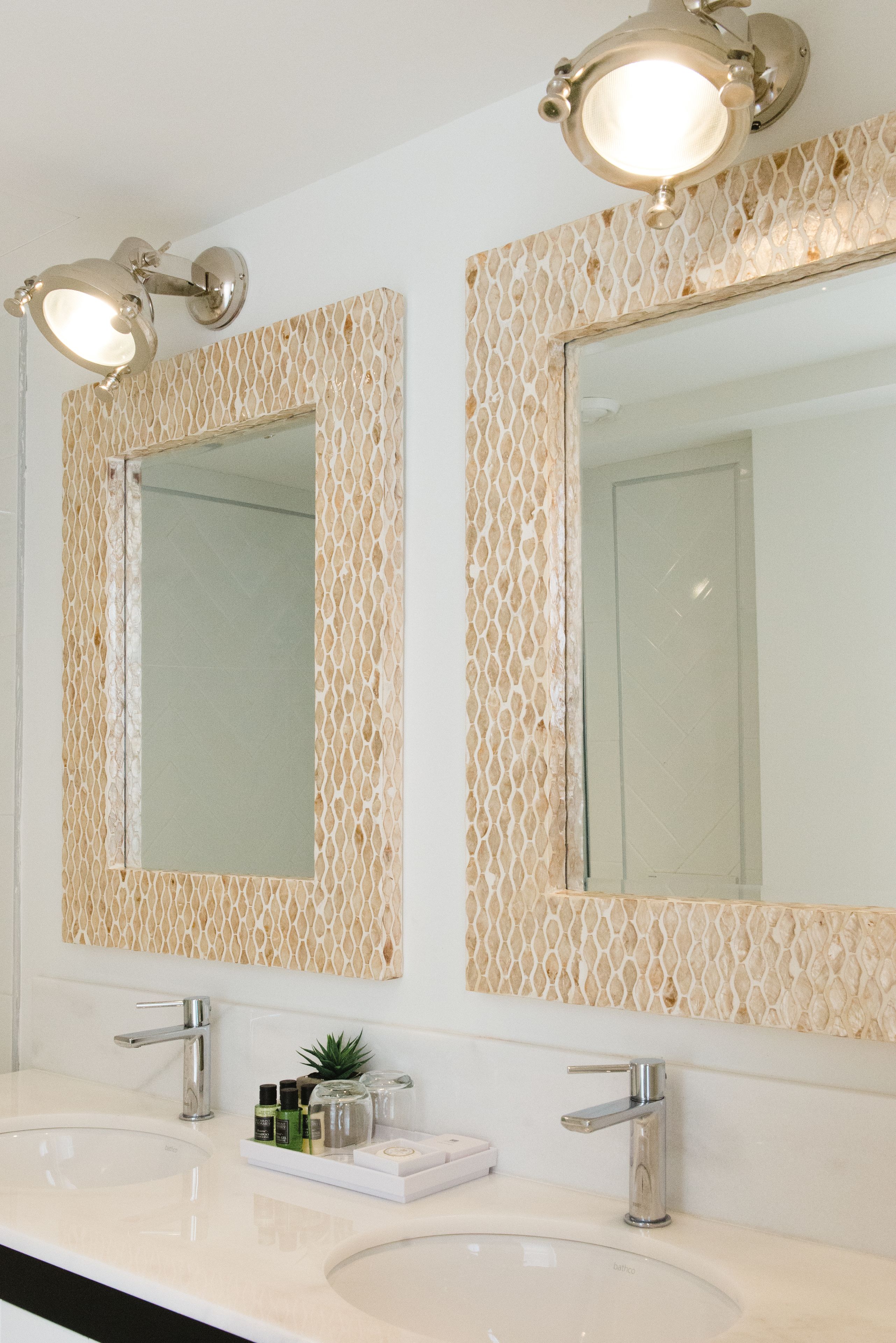 A bathroom with two sinks, each with a modern faucet, and a large mirror above.