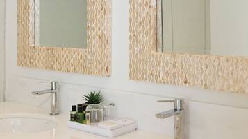 A bathroom with two sinks, each with a modern faucet, and a large mirror above.