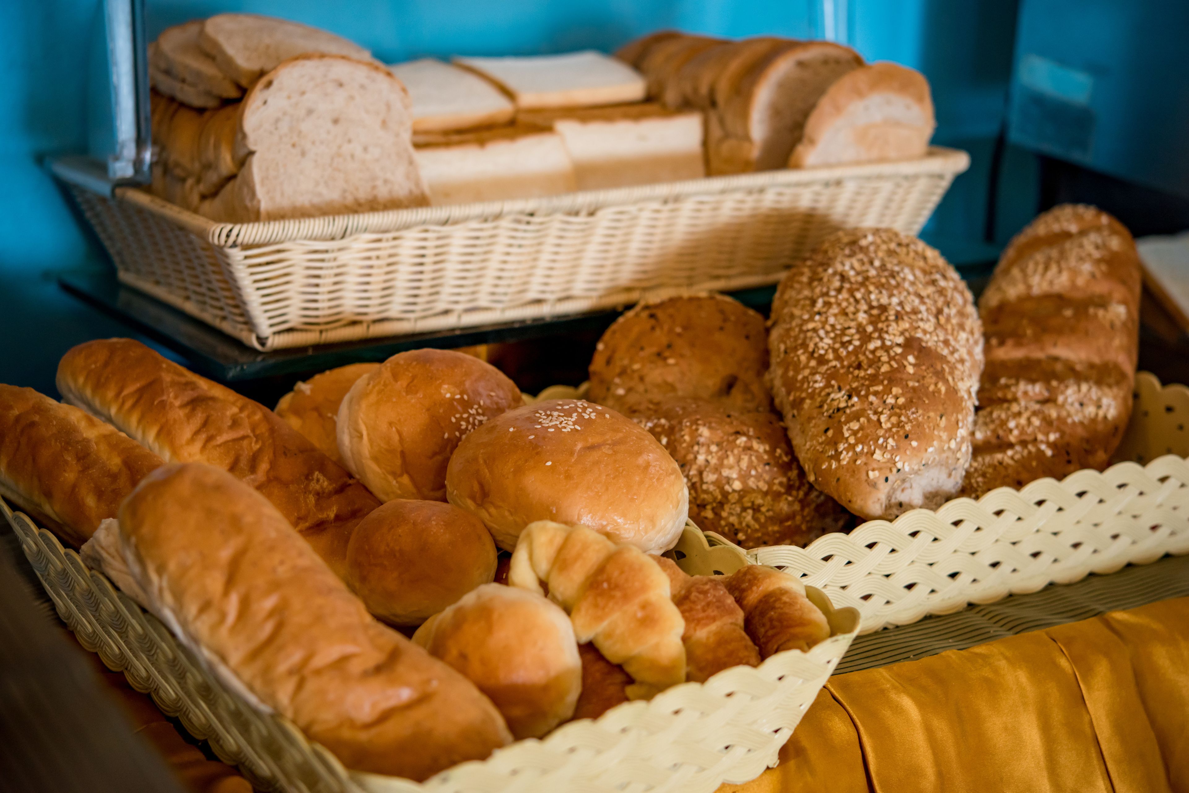 A variety of breads and rolls displayed in baskets.
