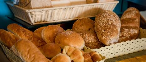 A variety of breads and rolls displayed in baskets.