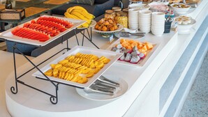 Een buffet met diverse gerechten en een zithoek met banken en een salontafel.