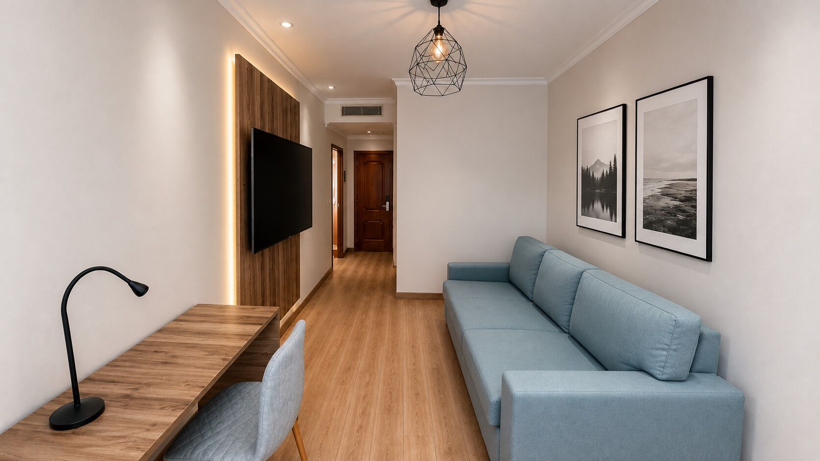 Una sala de estar moderna con televisor de pantalla plana, un sofá azul claro, una mesa de centro de madera y una lámpara colgante.