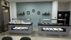 Disposição de buffet com duas estações de serviço, cada uma com uma vitrine de vidro e diversas opções de comida.