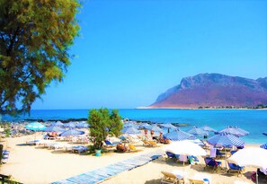 Privat strand, vit sandstrand, solstolar och parasoller