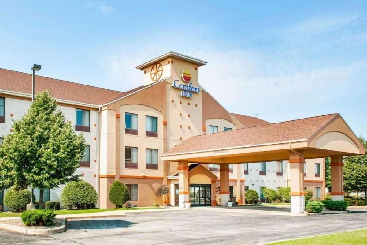 A Comfort Inn hotel with a central entrance, multiple windows, and a parking lot.